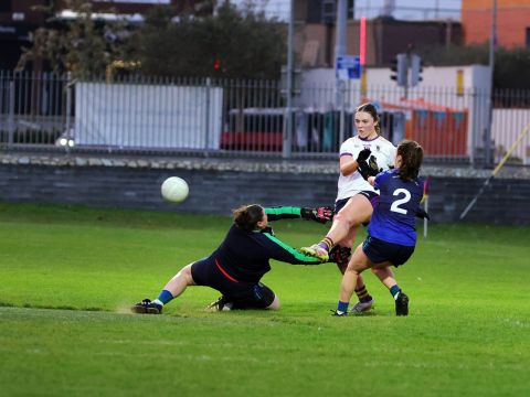 Crokes no 19 kicks ball between St Sylvesters no 2 and goalkeeper towards goal
