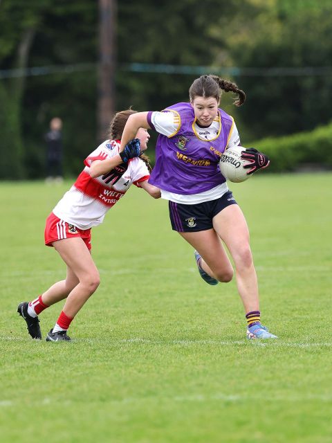Kilmacud goalkeeper with ball in hand, running past tackle