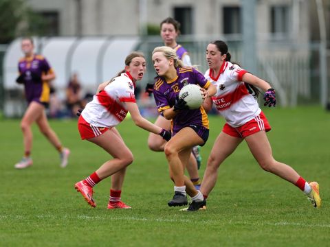 Kilmacud no 12 running through two tacklers